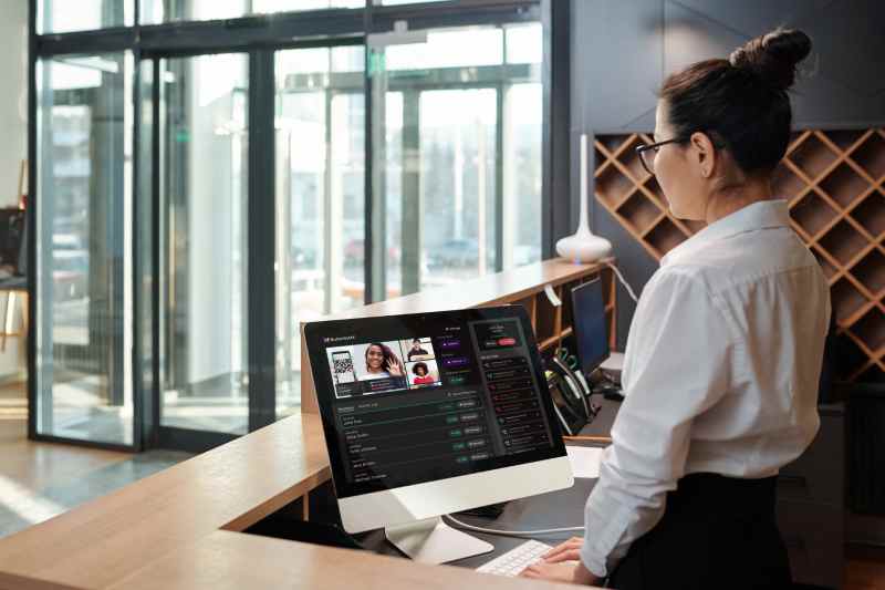Woman using front desk software at a hotel.